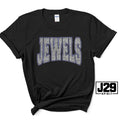 A black short-sleeve t-shirt with 'JEWELS' printed across the chest in a gray and white textured pattern with a blue outline. The shirt is styled with a knot at the bottom hem and features a 'J29 SPIRIT' logo overlay in the bottom right corner.